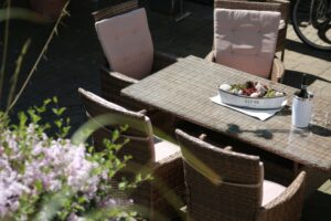 Außenbereich der Ferienwohnung Koblenz- ein Tisch und viele Sitzplätze für Frühstück in der Sonne